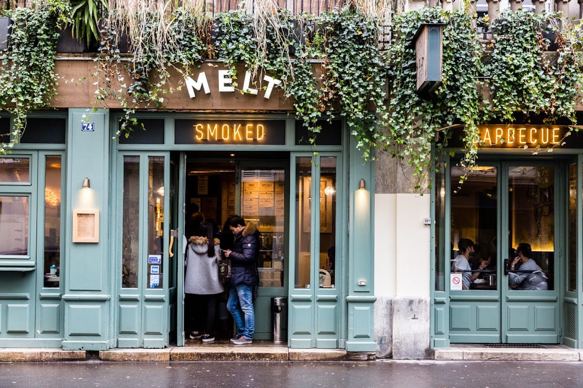 ivy-covered exterior of a barbecue restaurant with large windows.