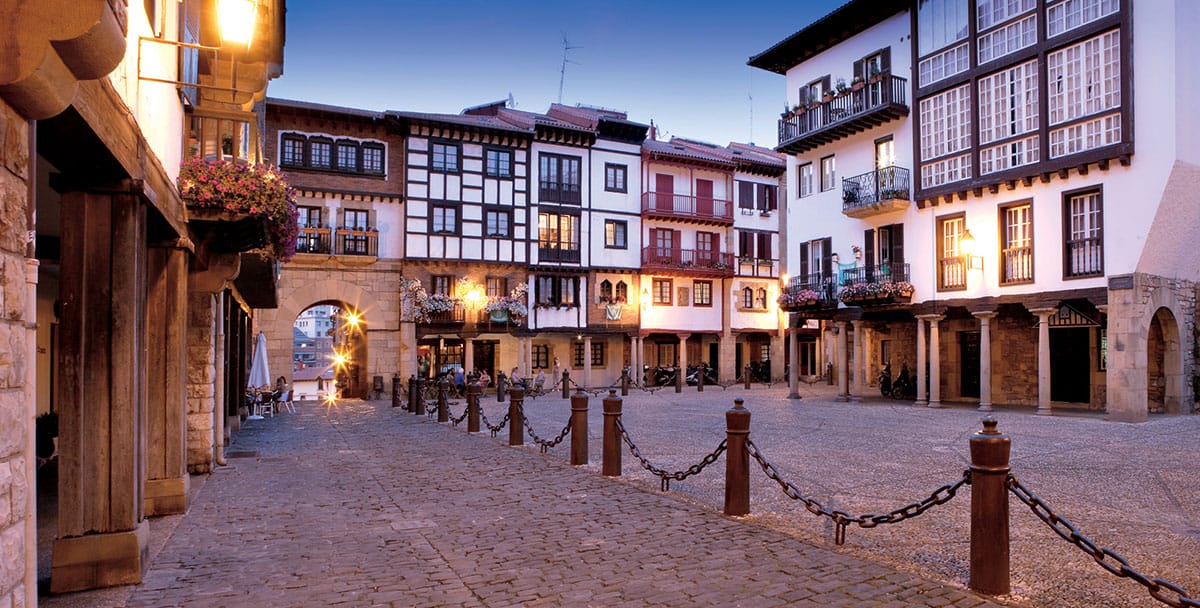colorful four-storied homes lining a stone street.
