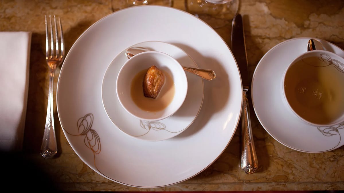 mini madeleine in a bowl with a vanilla milk sauce.