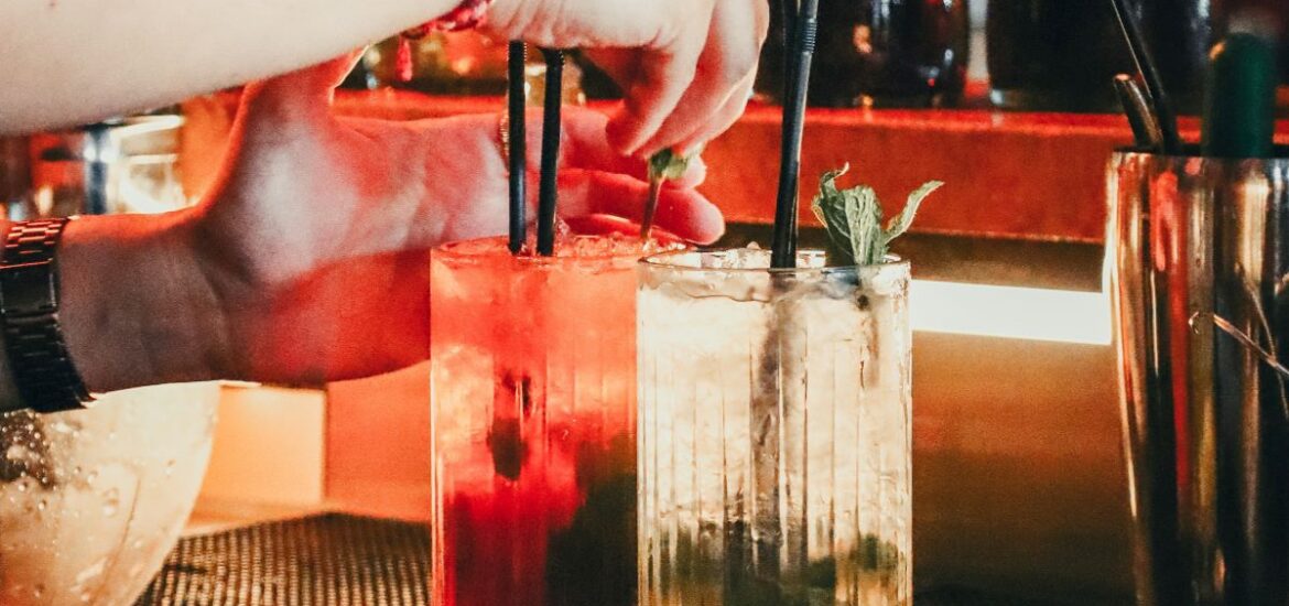 A bartender making two cocktails for bar goers in Bordeaux.