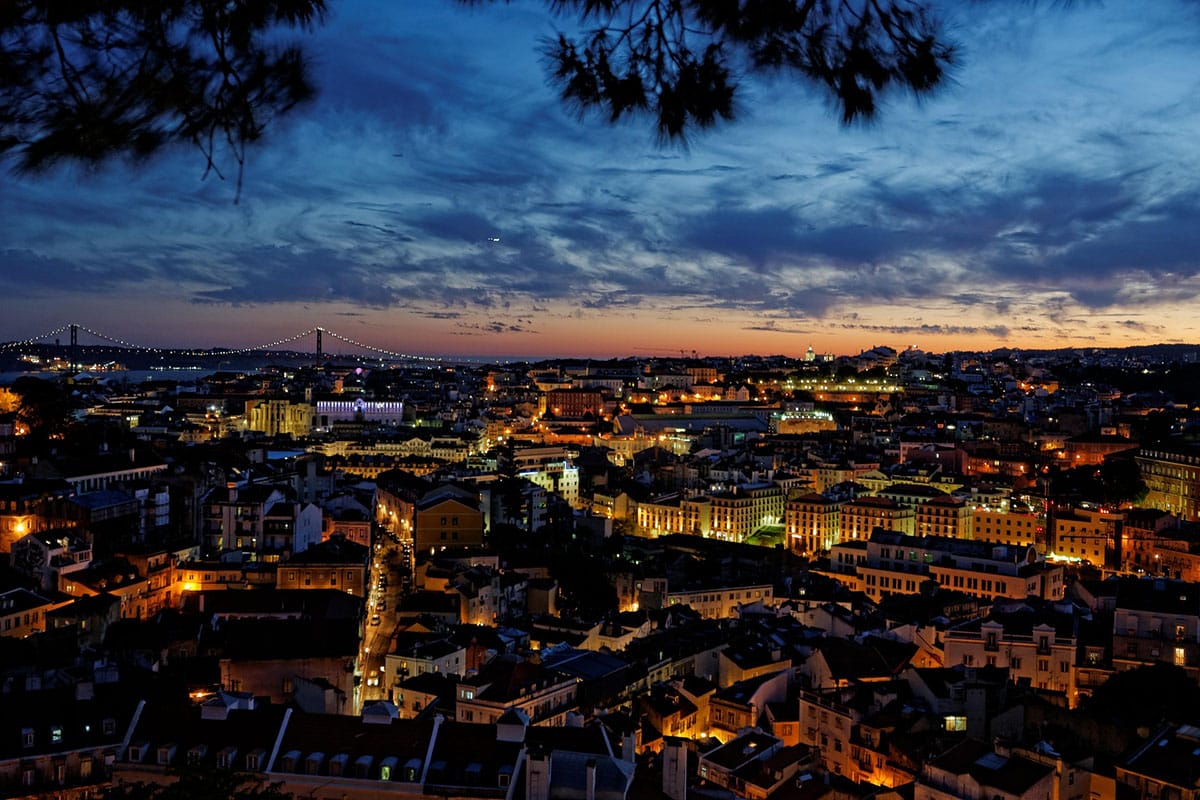 illuminated buildings in Lisbon at twilight from an aerial view.