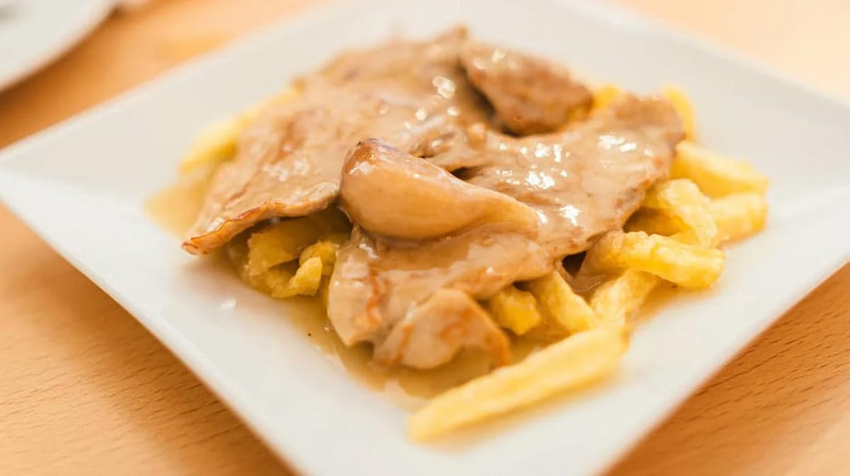 dish of chicken and potatoes with solomillo al whisky on top.