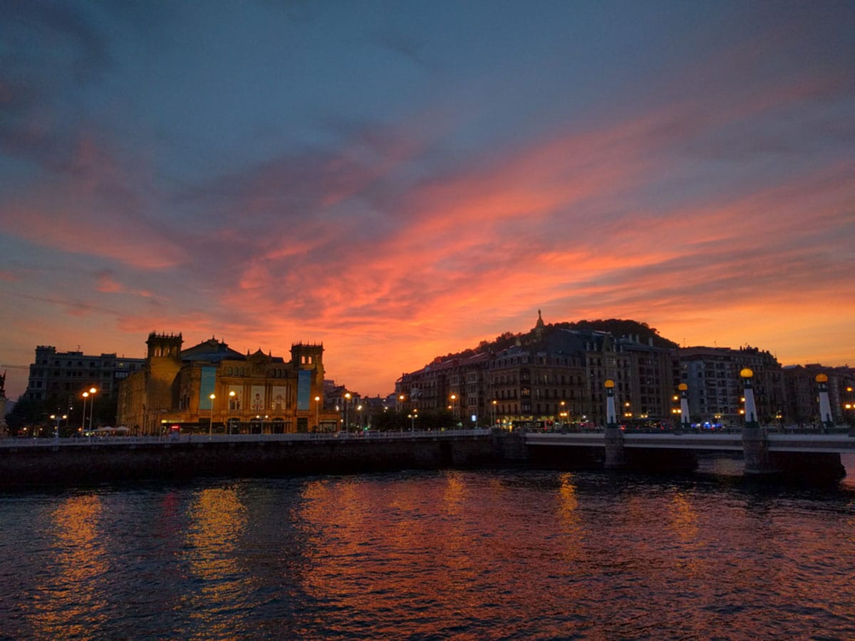 blue and pink sunset over historic buildings near water.
