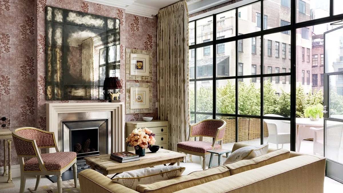chairs and a sofa near a fireplace with large windows.