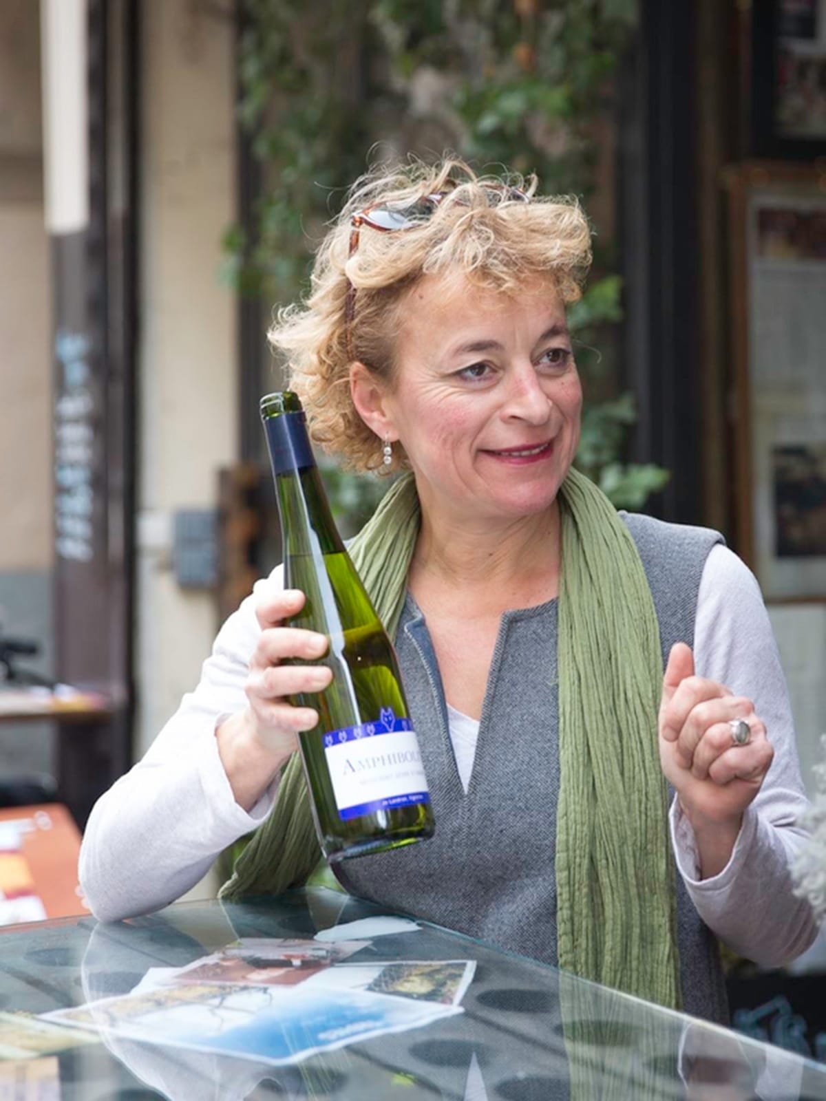 lady holding a green glass bottle of champagne.