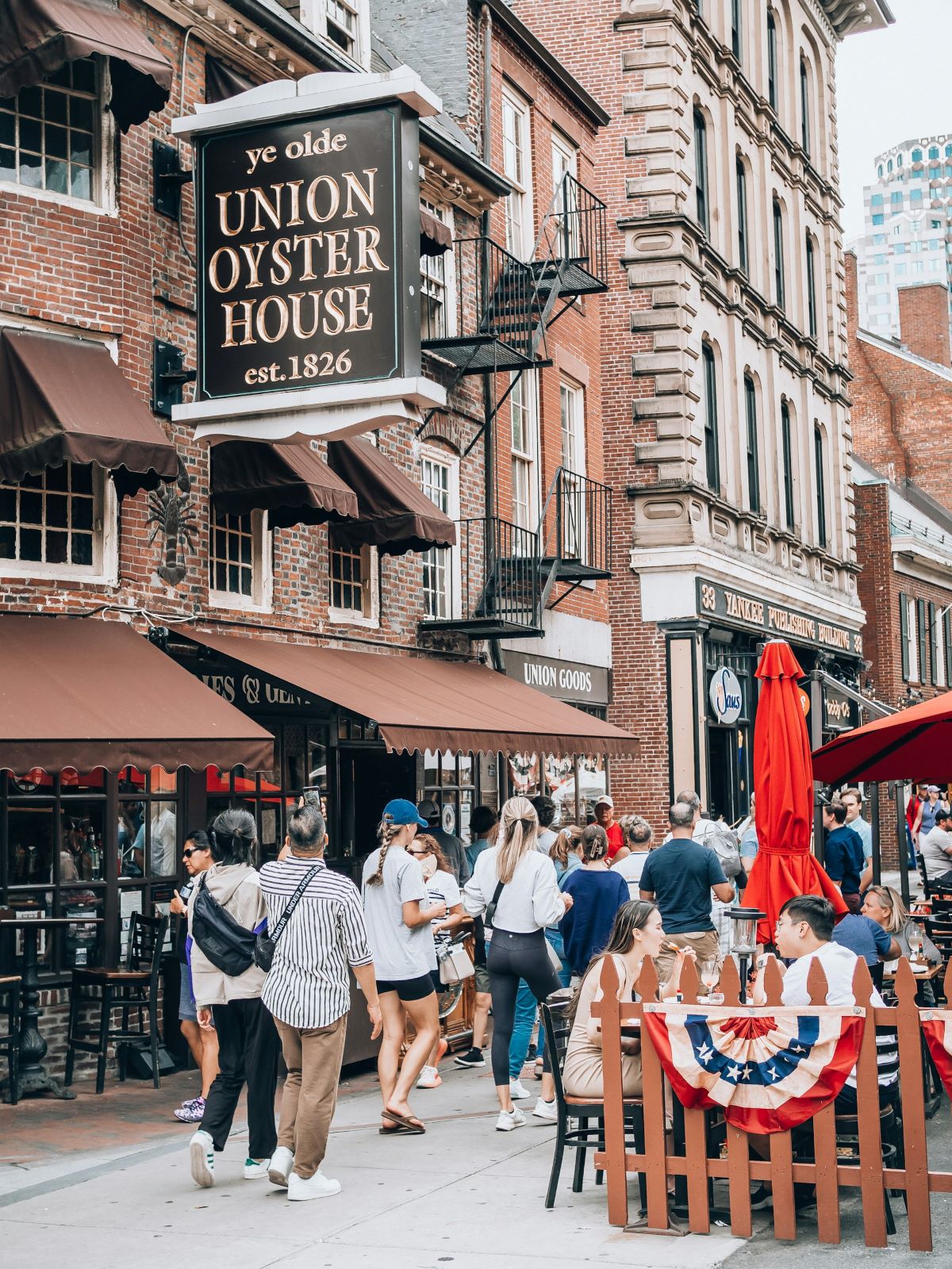 People walking around looking for Boston famous foods on a busy street. 